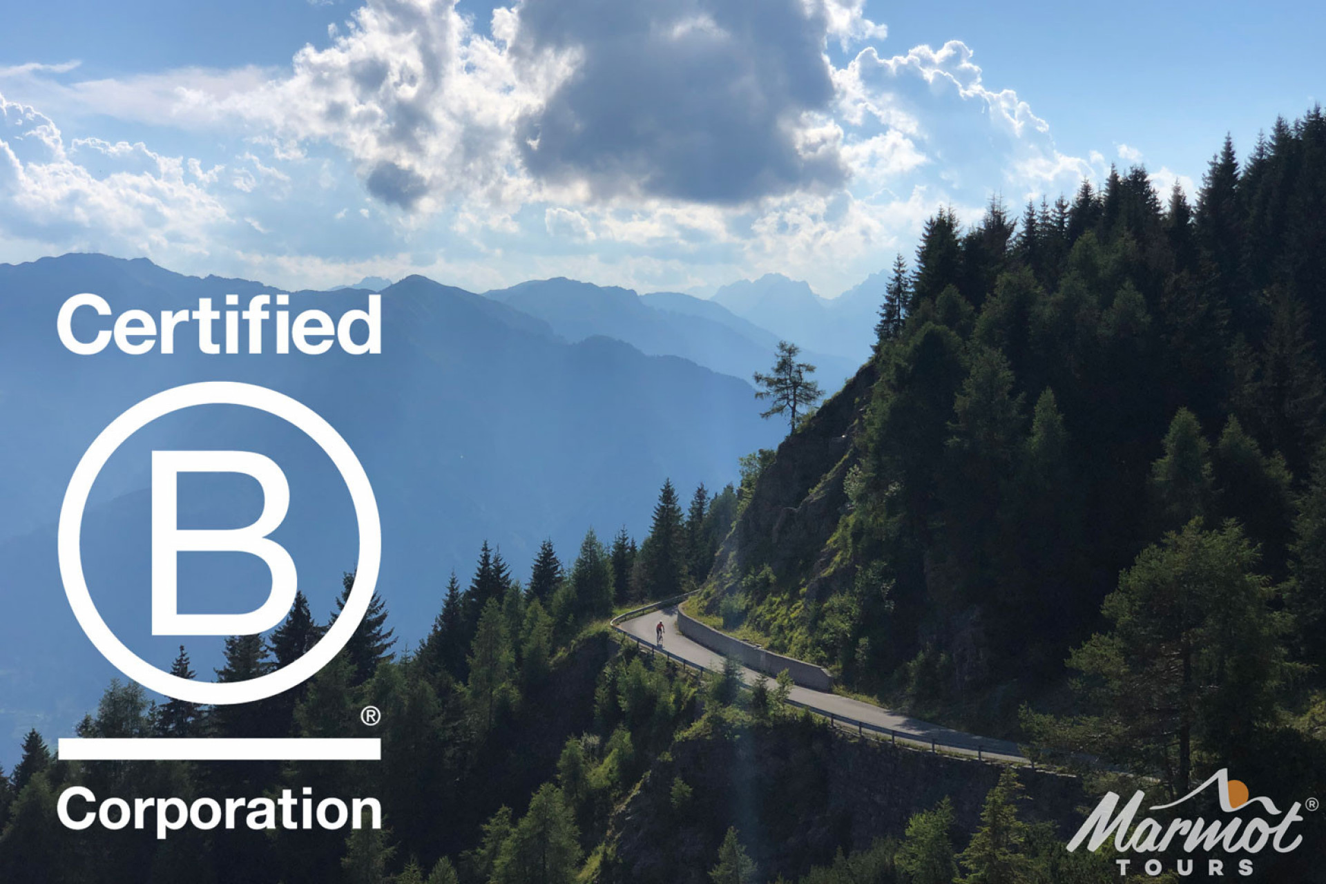Pair of cyclists riding Zoncolan climb on forested road with background mountain peaks on Marmot Tours road cycling holiday with B Corp logo overlaid