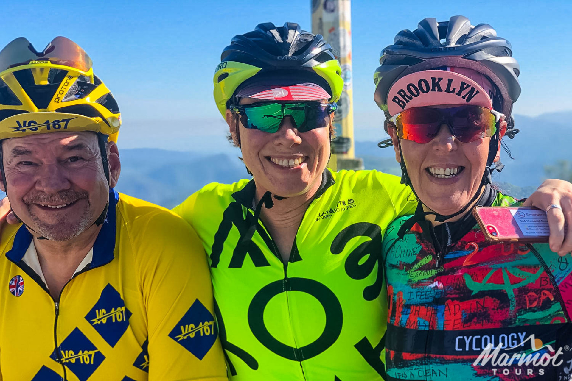Three cyclists smiling at summit of Mont Ventoux on Marmot Tours guided European road cycling holiday