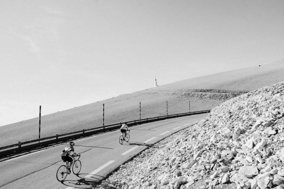 Black and white image of two cyclists climbing Mont Ventoux with full support from Marmot Tour road cycling holidays