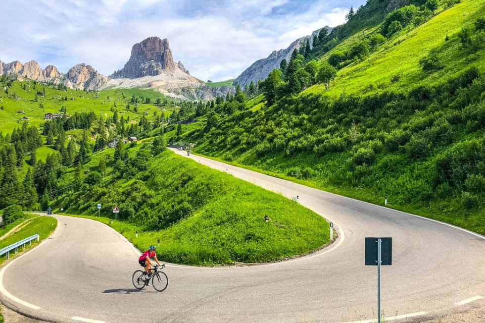 Cyclist climbing hairpin bend on full support cycling mini break Dolomites Italy with Marmot Tours