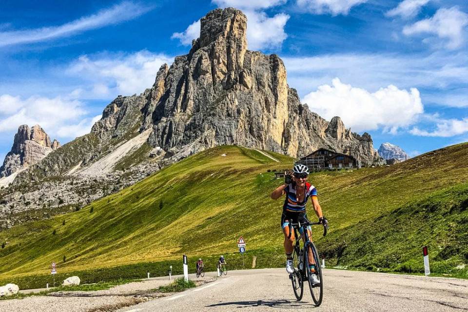 Female cyclist smiling on Passo Giau on Marmot Tours guided road cycling mini break Dolomites Italy